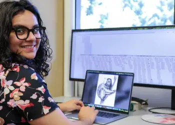 La investigadora Prajna Hebbar ante pantallas con datos genómicos y la imagen de un tití