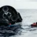La parte posterior de Starship del Vuelo 13 flotando en el océano Índico junto a una embarcación de recuperación