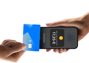 Una tarjeta sin contacto se acerca a un iPhone que muestra una pantalla de cobro