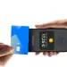 Una tarjeta sin contacto se acerca a un iPhone que muestra una pantalla de cobro