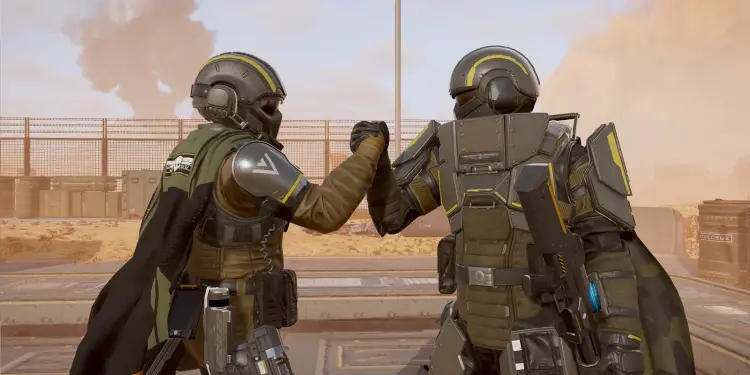 Dos Helldivers con las armaduras del Warbond Ironclad Democracy se saludan en un escenario desértico