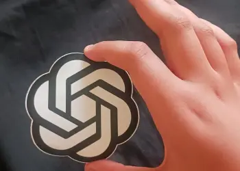Emblema de OpenAI sostenido en una mano