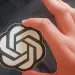 Emblema de OpenAI sostenido en una mano