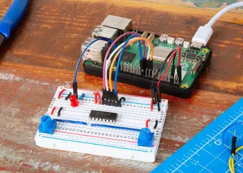 Una Raspberry Pi conectada a una placa de pruebas con un MCP3008, un LED y dos potenciómetros