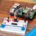 Una Raspberry Pi conectada a una placa de pruebas con un MCP3008, un LED y dos potenciómetros
