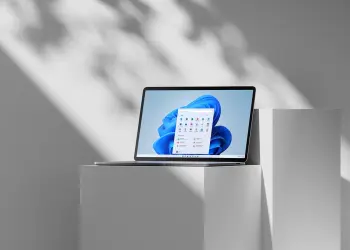 Un portátil muestra el escritorio y el menú Inicio de Windows 11