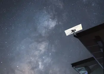 Antena de Starlink junto a un tejado de noche