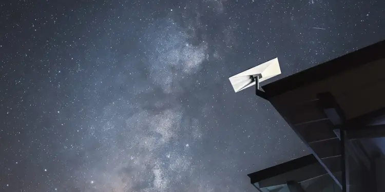 Antena de Starlink junto a un tejado de noche