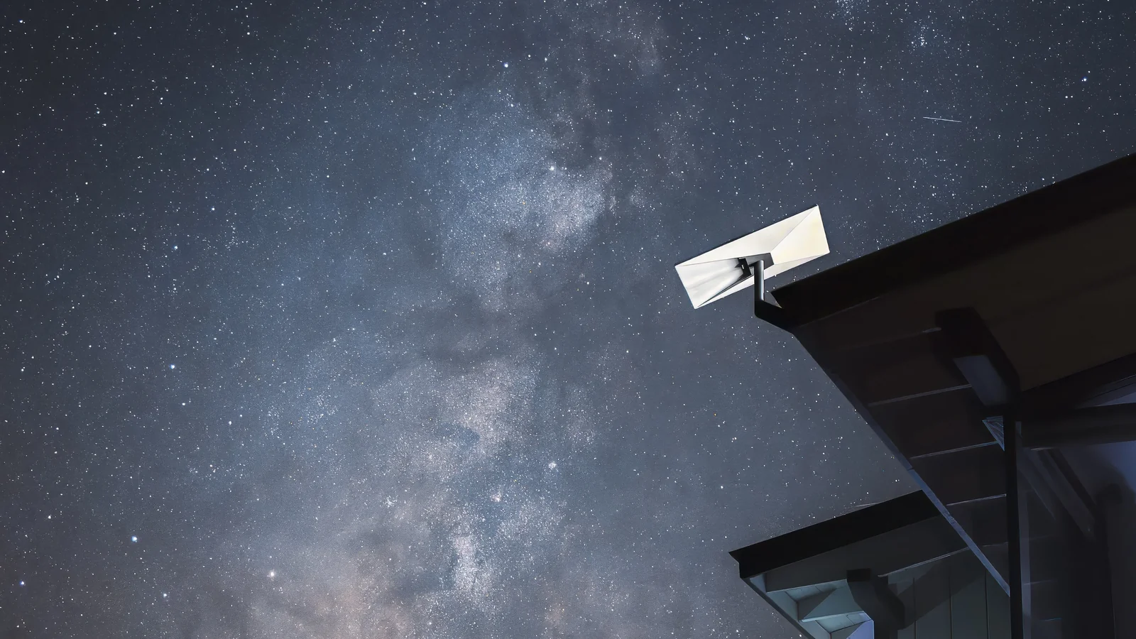 Antena de Starlink junto a un tejado de noche