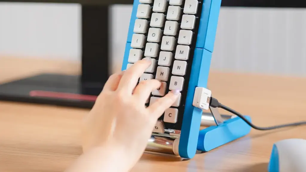 Una mano pulsa el teclado vertical azul